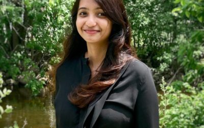 a photo of Deepthi Bathala standing in front of green foliage