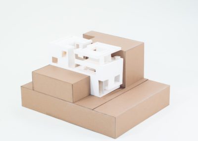 Exterior side view of architecture model in-between cardboard boxes