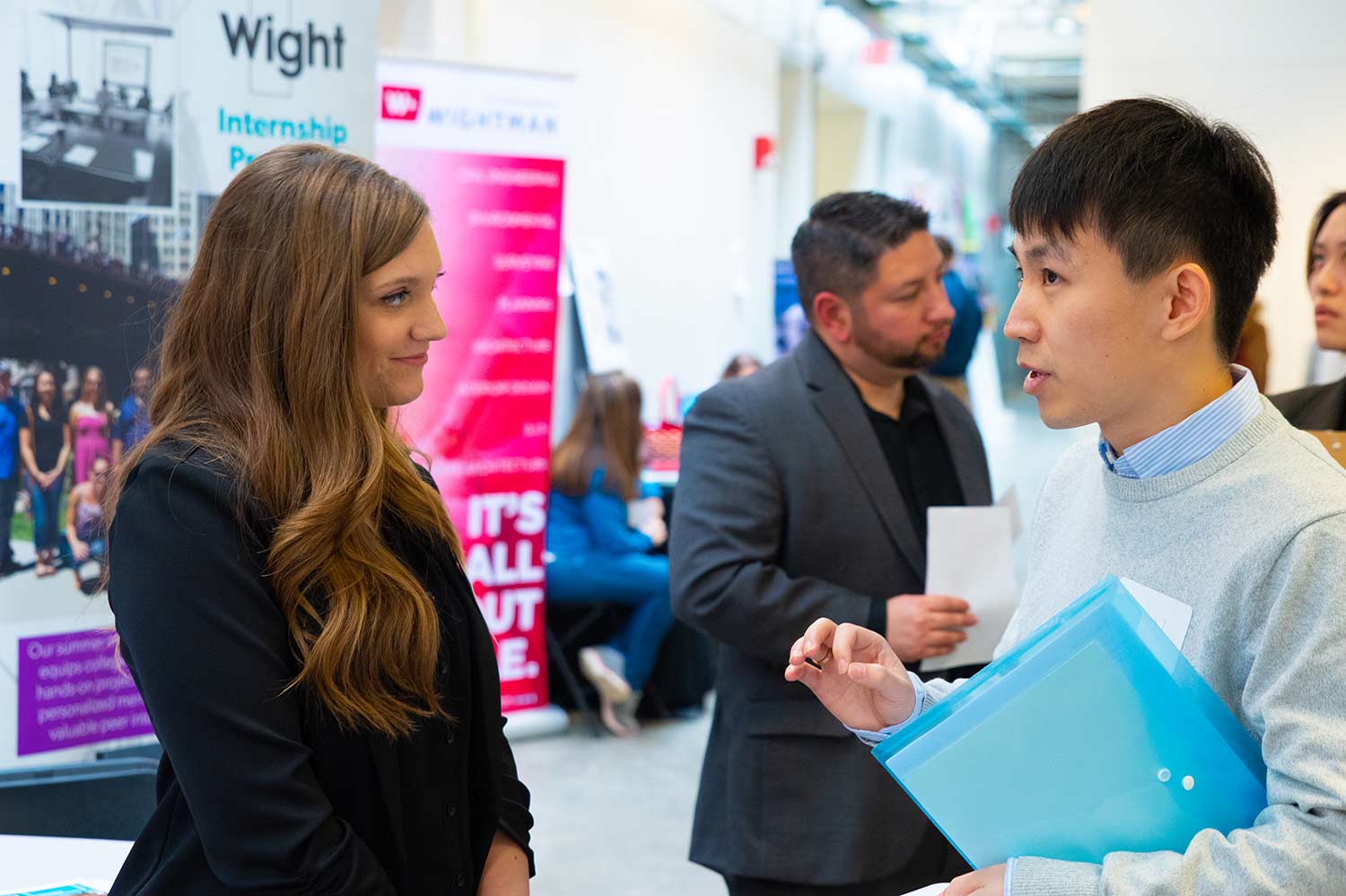 A man and woman speaking during a career fair.