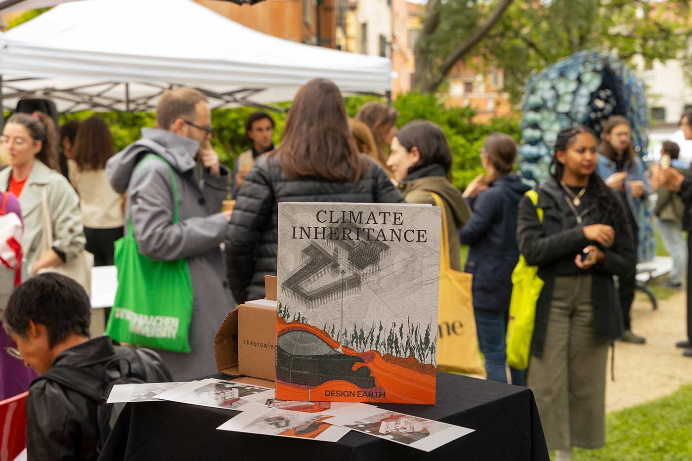 The cover of Climate Inheritance sitting on a table with people in the background