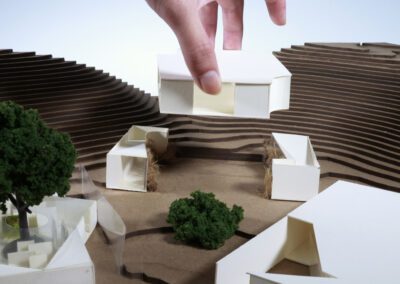 Up close hand placing architecture building into model