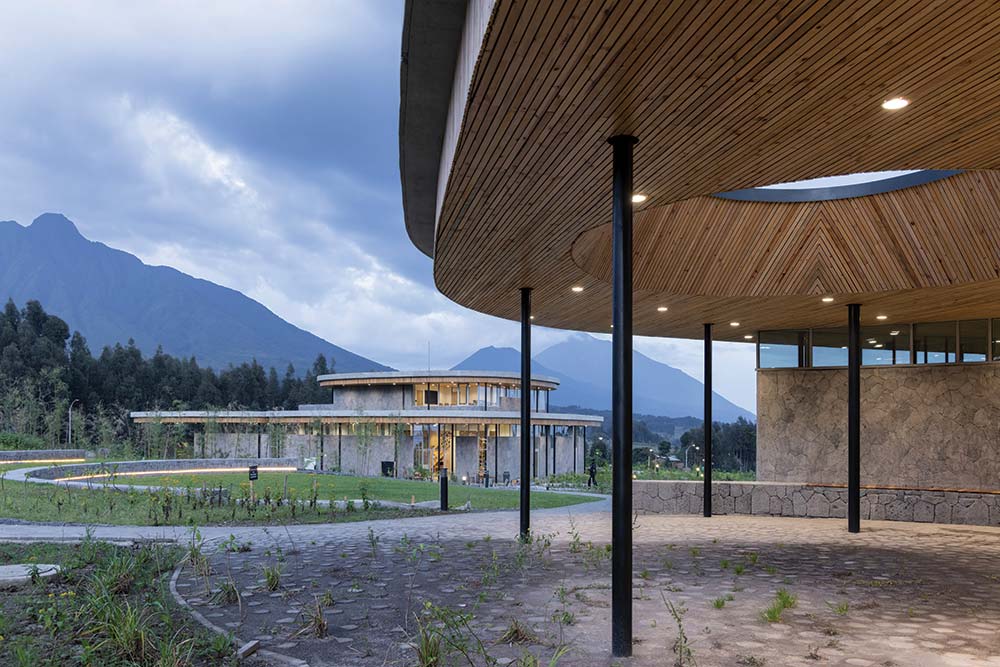 The campus buildings integrate into the landscape, transforming the site from an agricultural plot to a reforested, biodiverse landscape showcasing gorilla habitat ecologies.