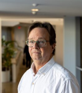 A portrait of Malcolm McCullough with a white shirt and glasses