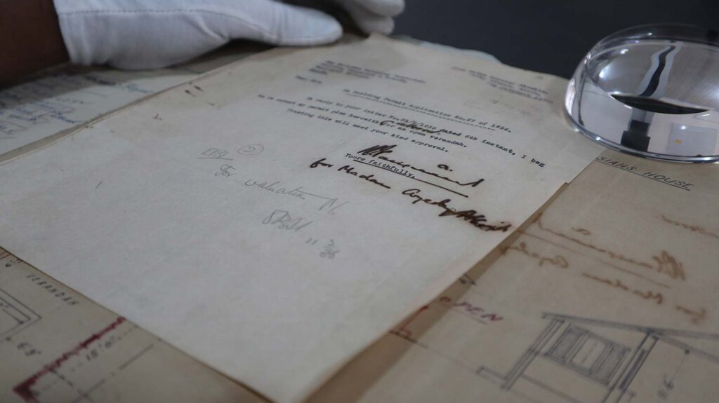 An old, yellowed building permit document with type and signatures.