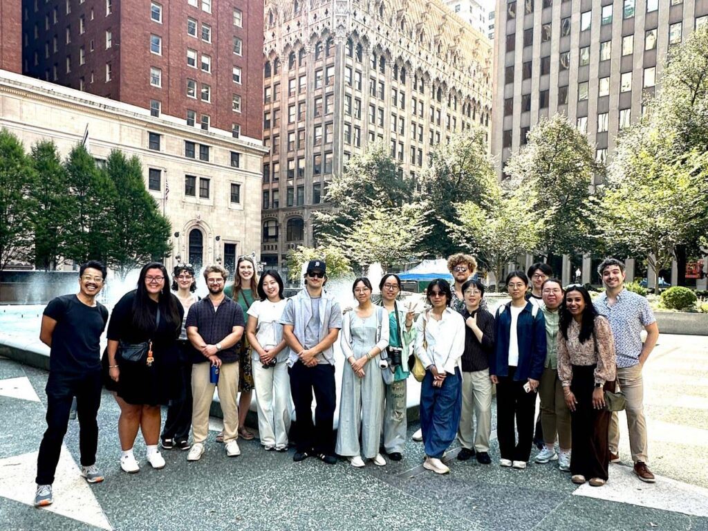 A group of people standing in a public square surrounded by tall buildings.