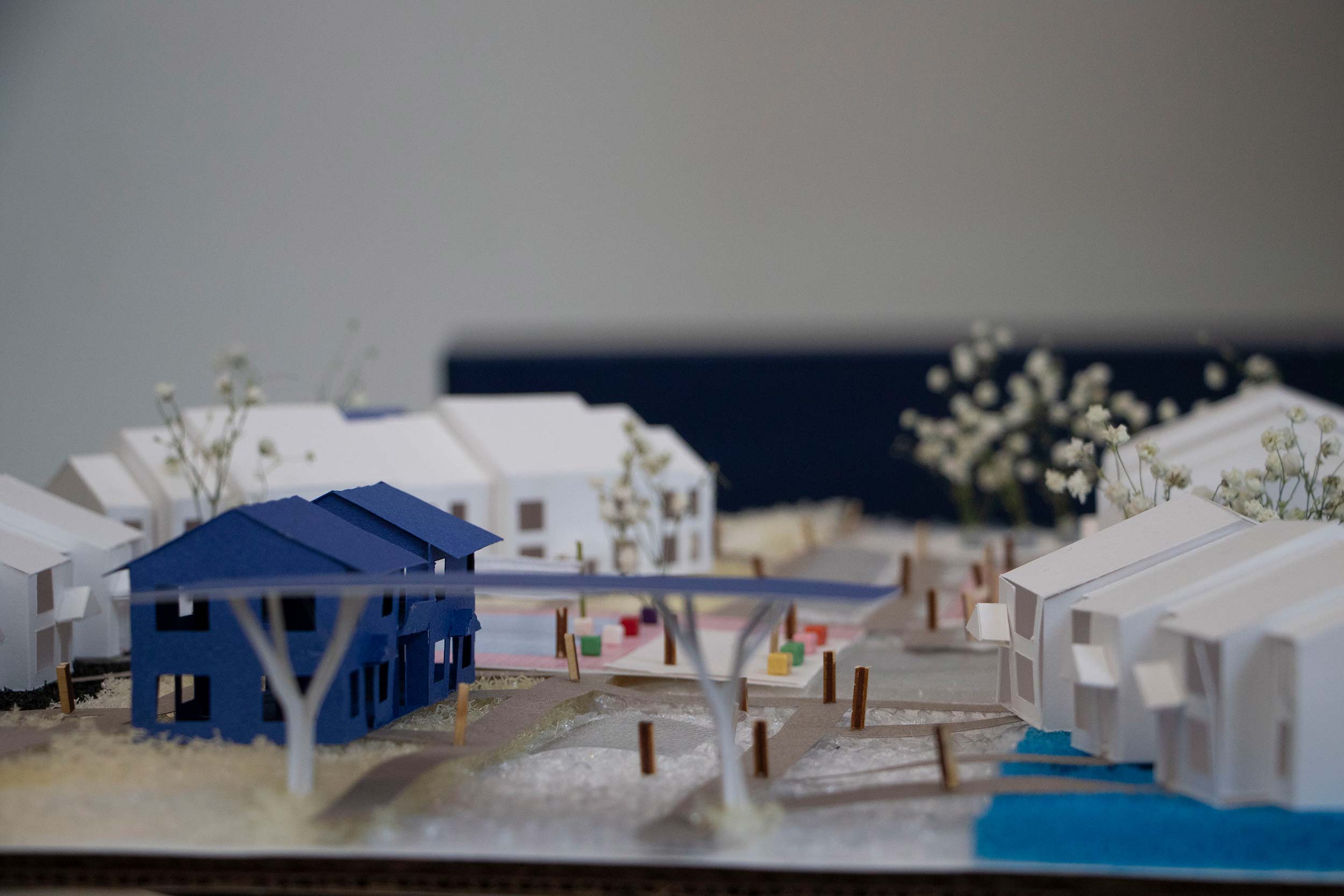 An architectural model of white buildings surrounding a blue building