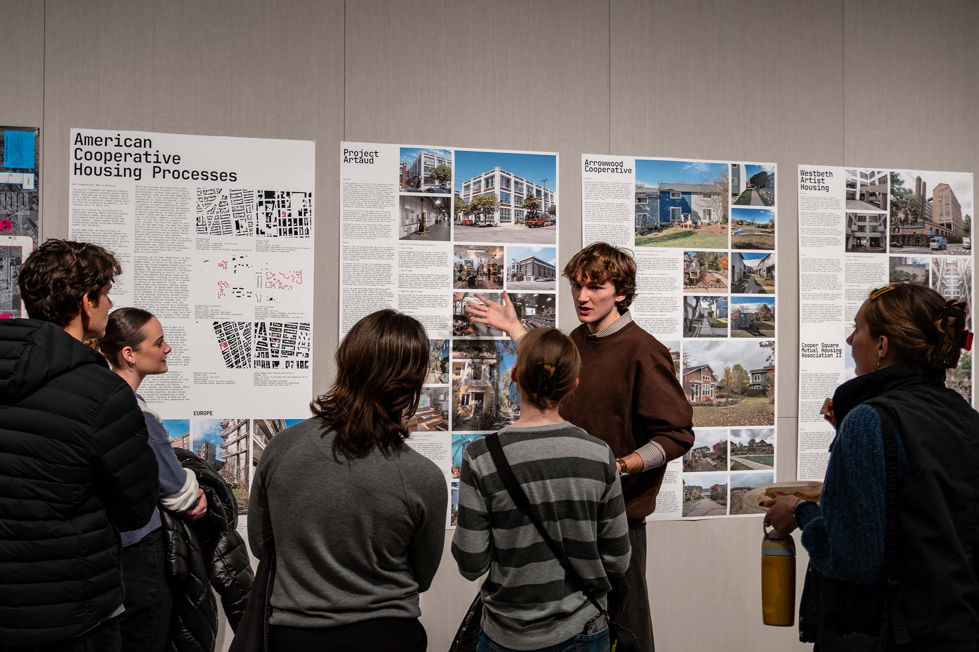 Nick Grosh standing front of posters presenting “A New American Housing”