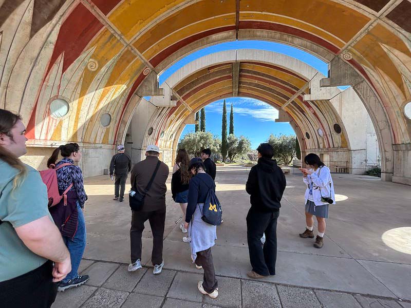 Students walk through and examine a cylindrical structure