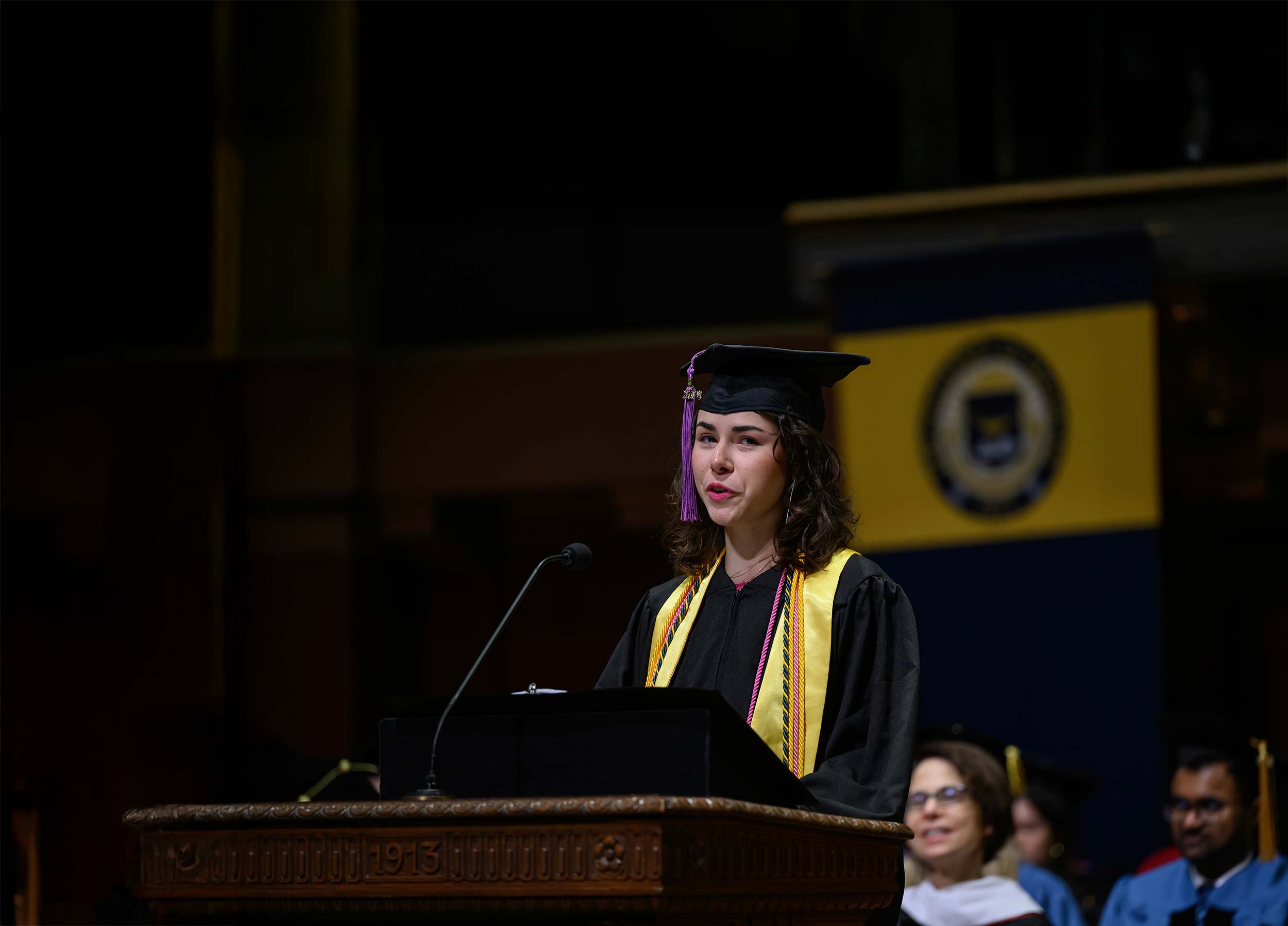 A graduate speaking at a podium