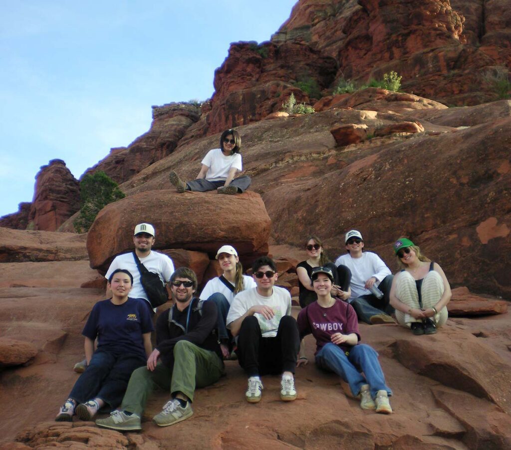 A group of students sitting on rocks in the desert