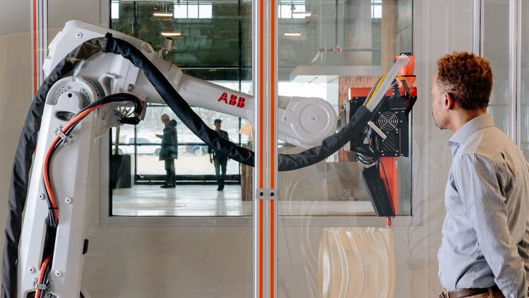 A person looking at a robot arm