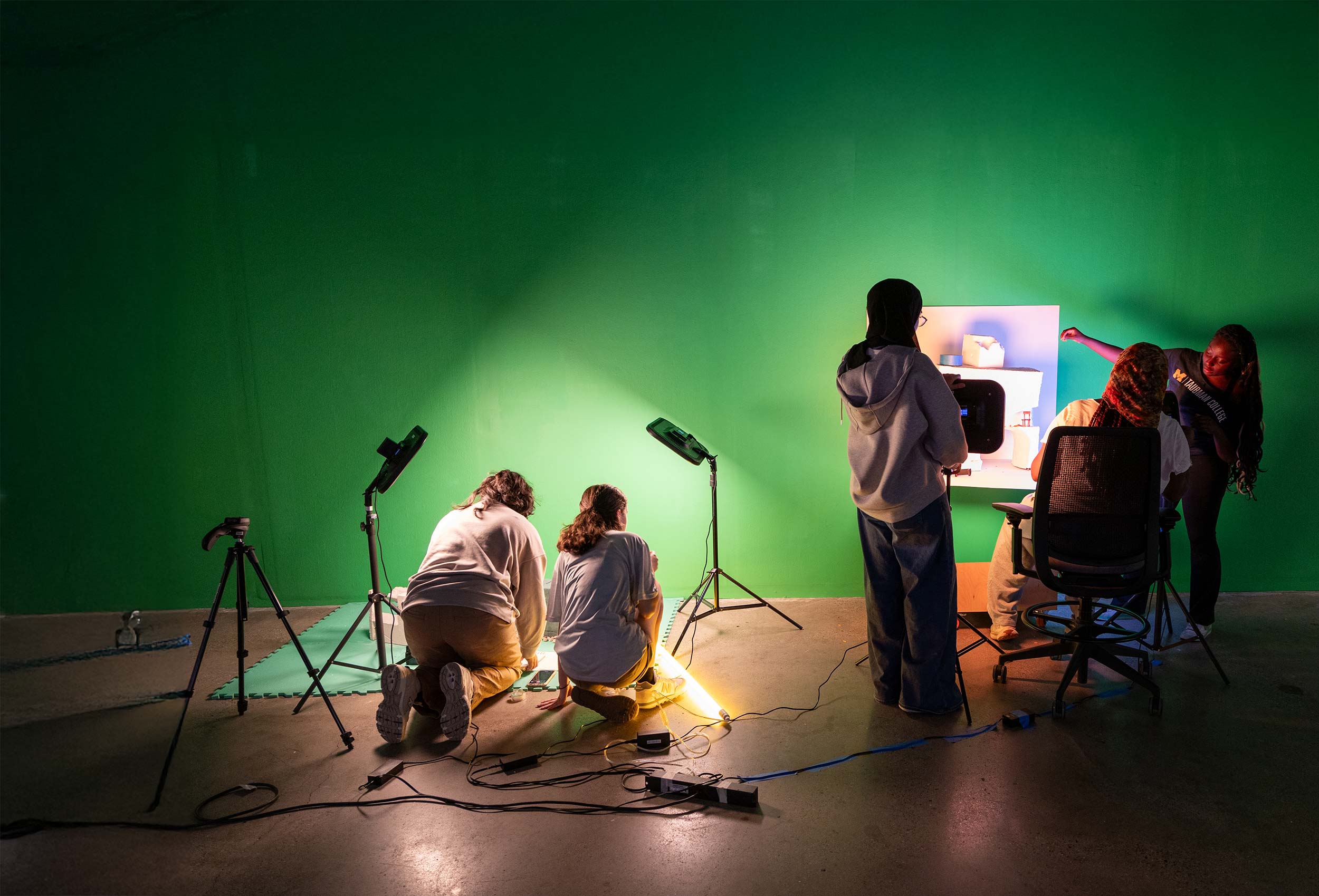 Students working in front of a green screen