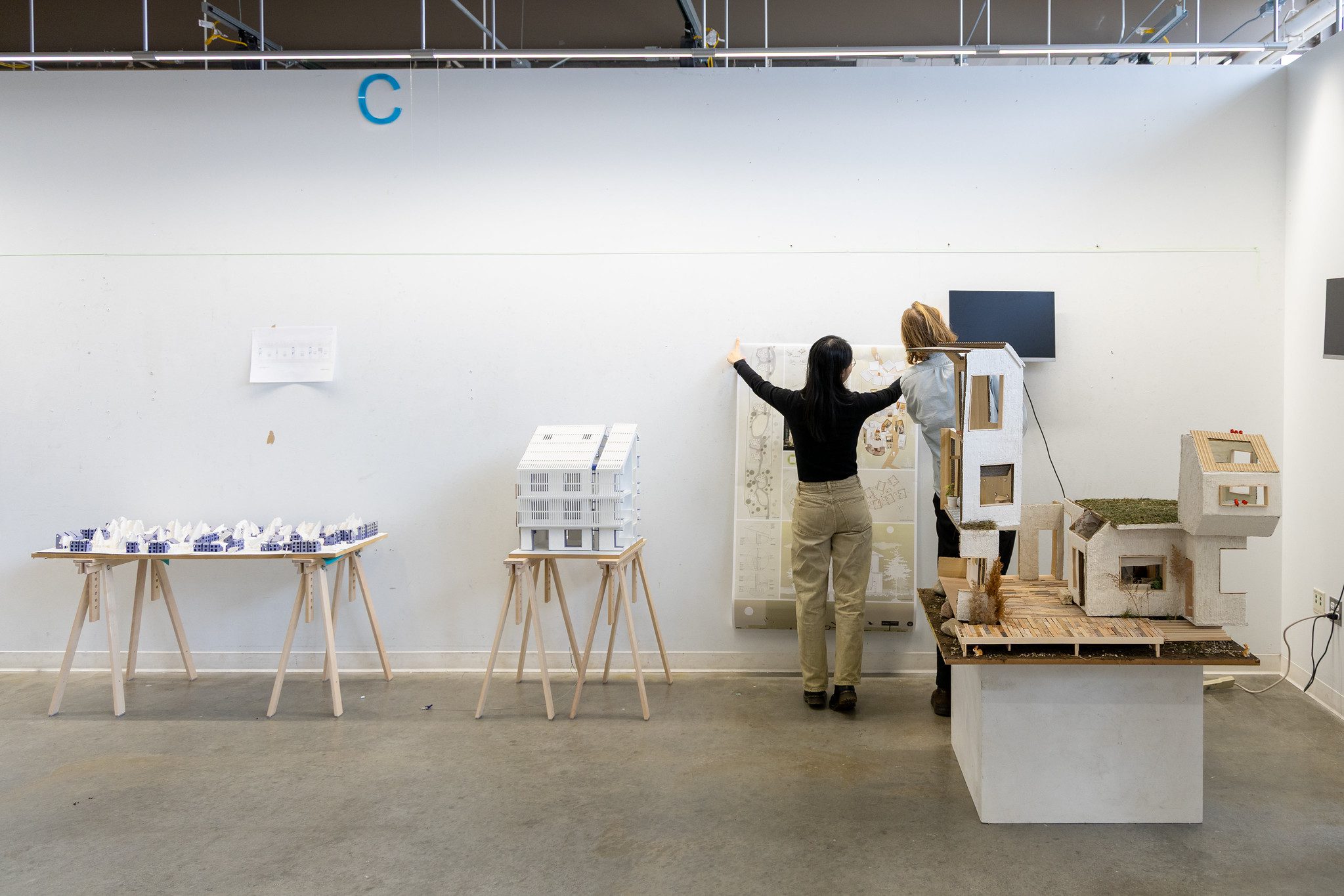 Students pin up their work on a wall