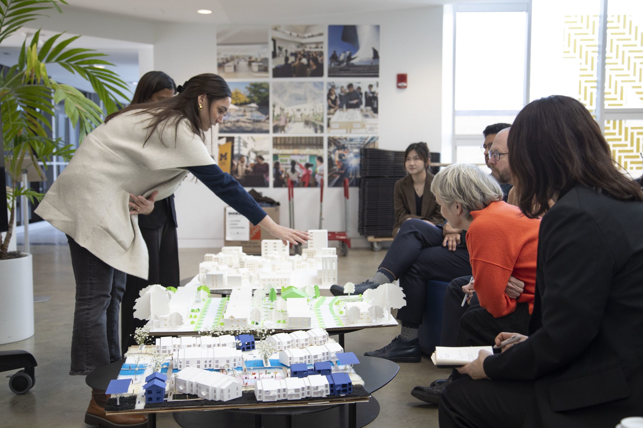 students and professors look at a city model