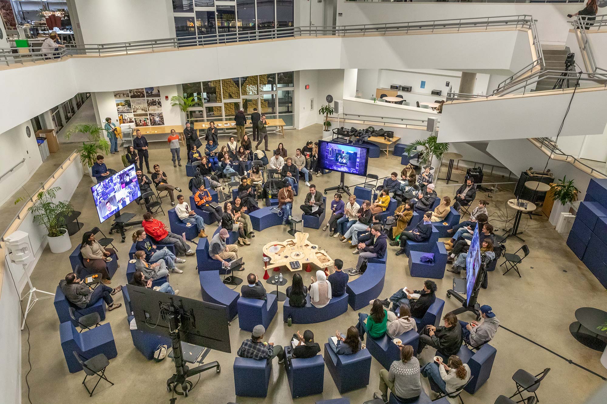 An overhead view of people sitting in a circle during a lecture.